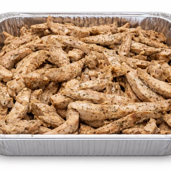 Seasoned chicken strips in a large aluminum catering pan, ready for serving.