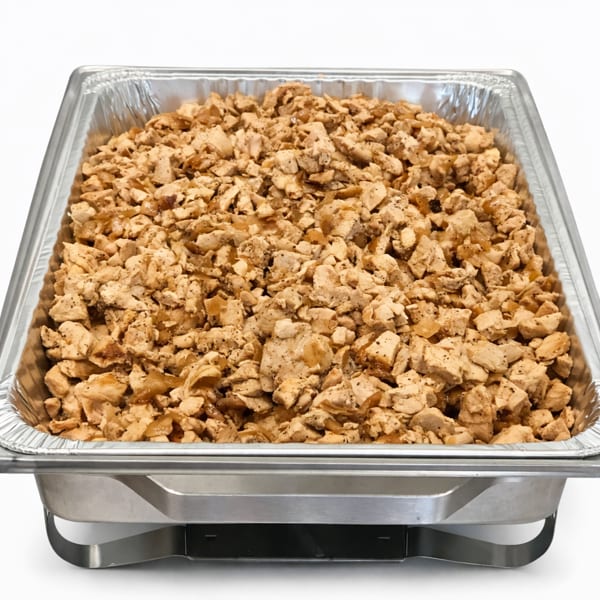 A catering pan filled with diced, seasoned chicken, ready for serving.