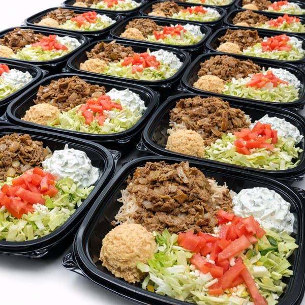 Rows of takeout containers filled with rice, meat, lettuce, tomatoes, hummus, and tzatziki.